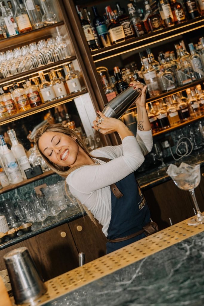 bartending woman shaking a cocktail