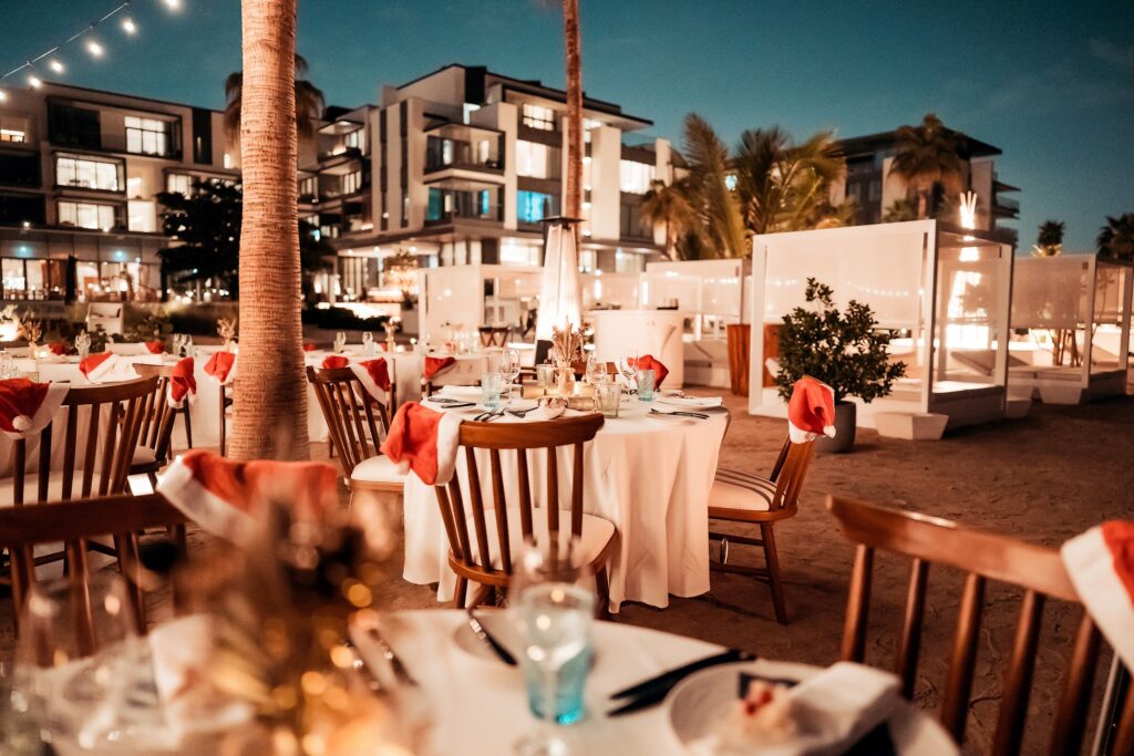 charming beach reception adorned with white and red tablecloths, firelight, and a cozy atmosphere for a holiday celebration