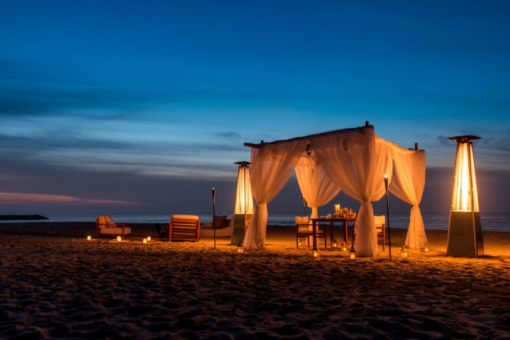 A romantic beachfront dinner for two under the stars, featuring candlelight, private cabanas, and live acoustic music