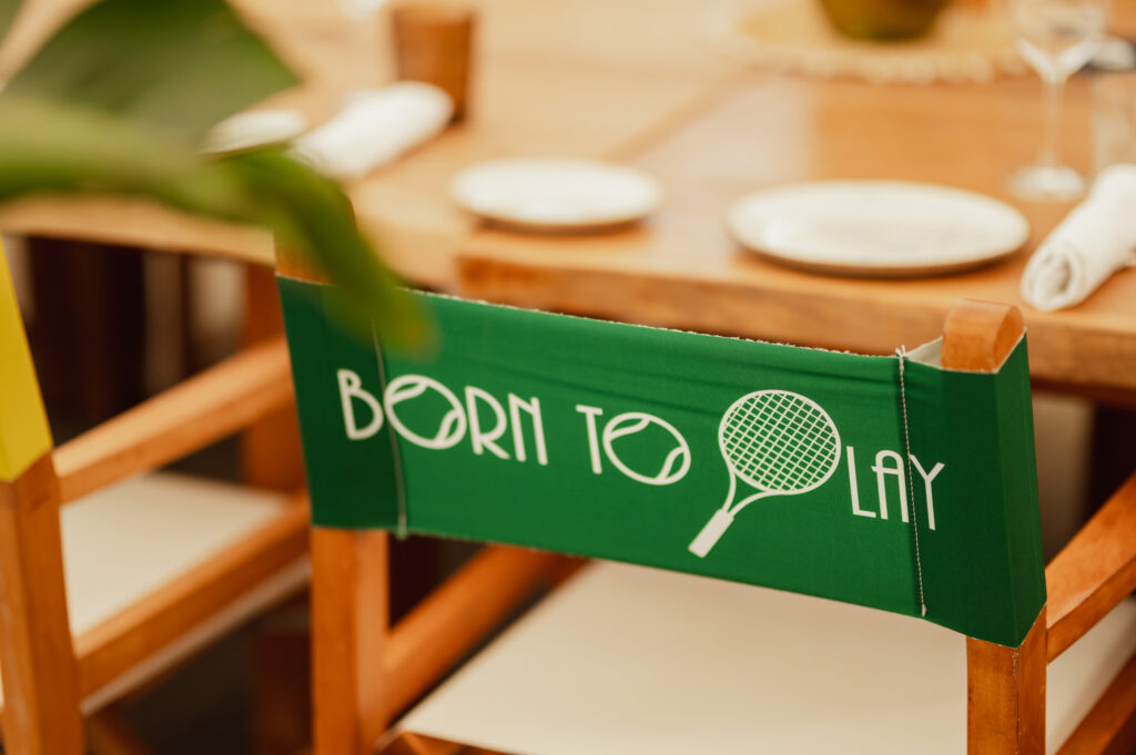 A deck chair with the words "born to play" printed on the fabric