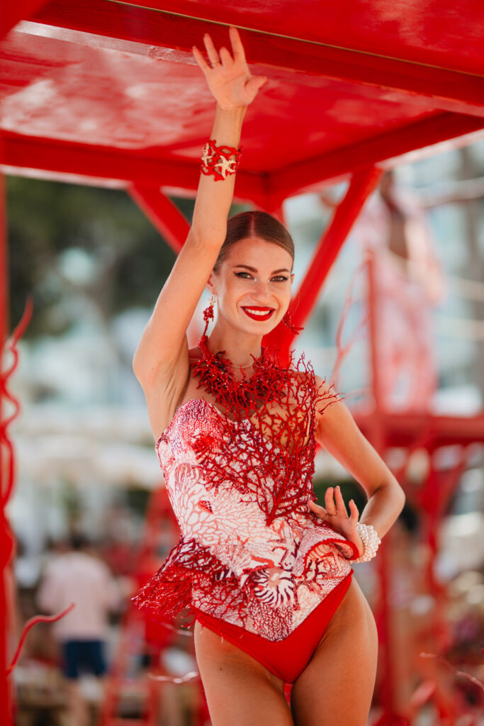 Women in red bodysuit, smiling and dancing