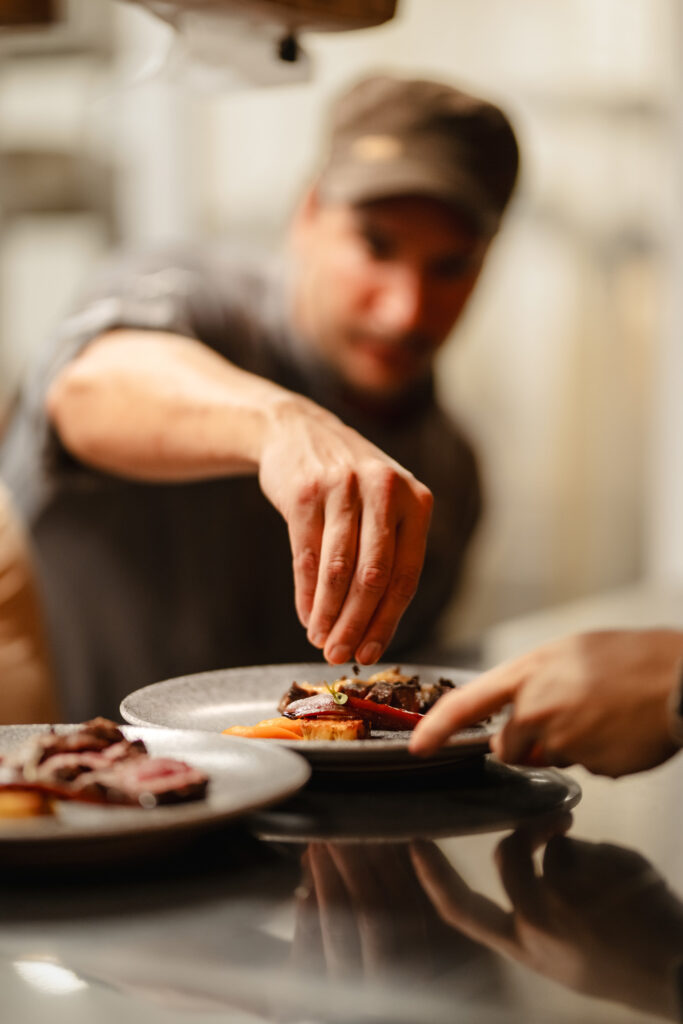 A chef garnishing a plate of food