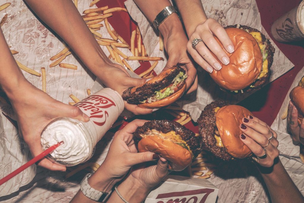 group of friends with burgers and fast food
