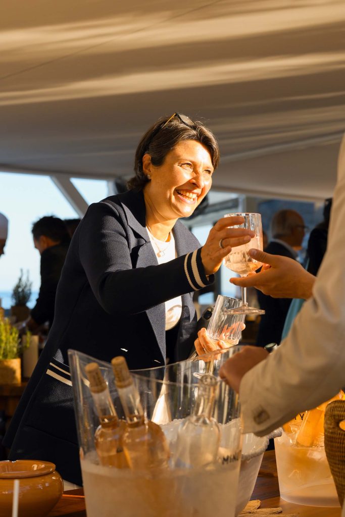 Lady serving drinks to guests, smiling