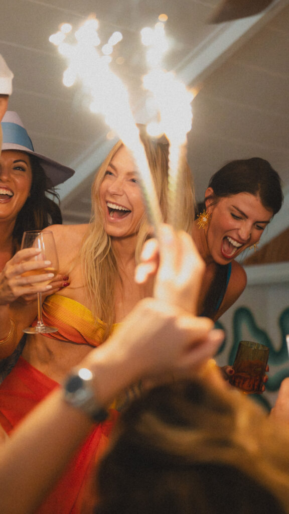 Women smiling and laughing while holding sparklers