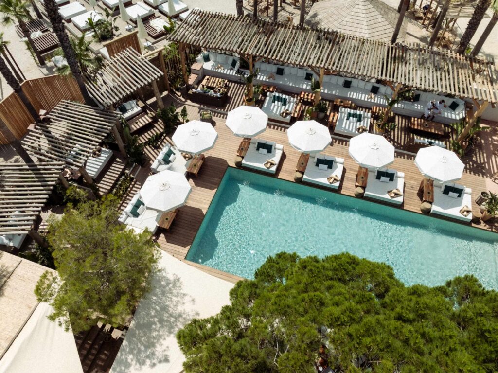 Birds eye view of corner of a pool area with sunbeds and umbrellas